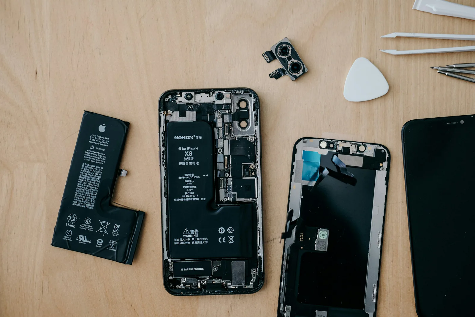 iPhone opened up with its battery removed beside it