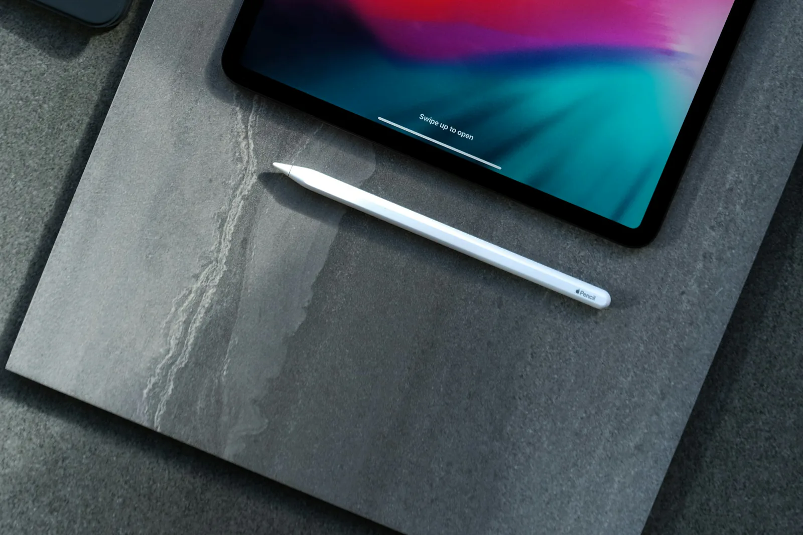 iPad and stylus on a dark table