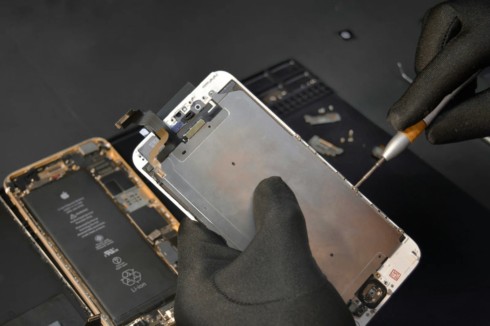 Phone screen being lifted off the frame during a repair